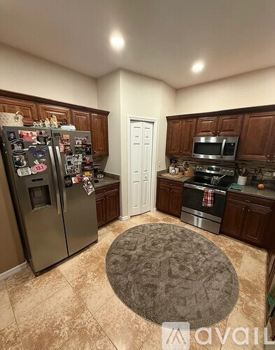 A kitchen with a refrigerator, oven, and microwave.