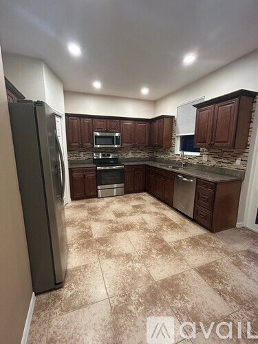 A kitchen with a refrigerator, oven, and microwave.