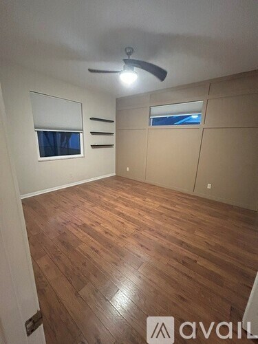 A bedroom with a bed, nightstand, and a ceiling fan.