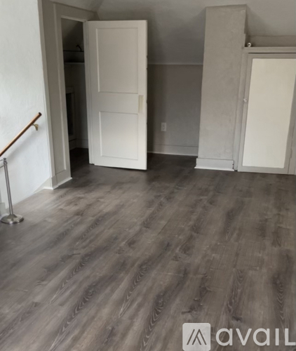 A room with a wooden floor and a white door.