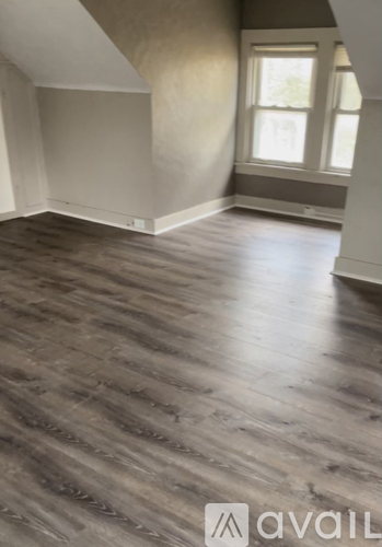 A room with wooden flooring and a window.