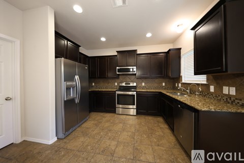 A kitchen with black cabinets and a granite countertop.
