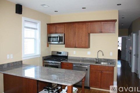 A kitchen with a granite countertop and wooden cabinets.
