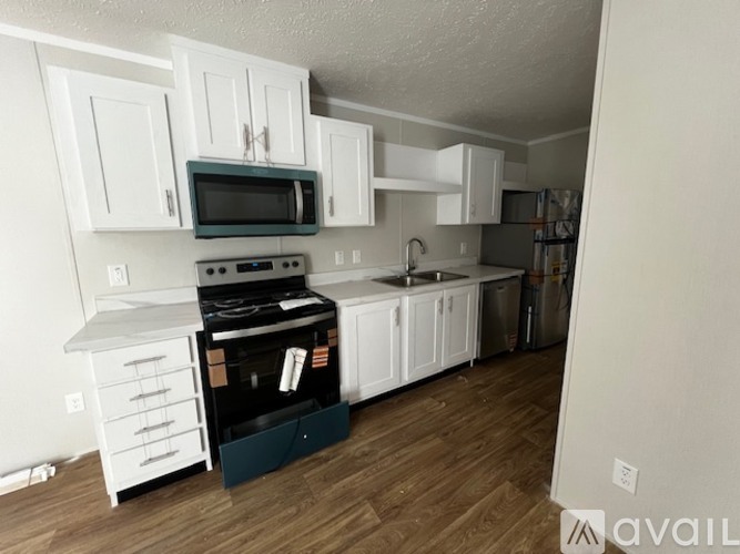 A kitchen with white cabinets and a black stove top oven.