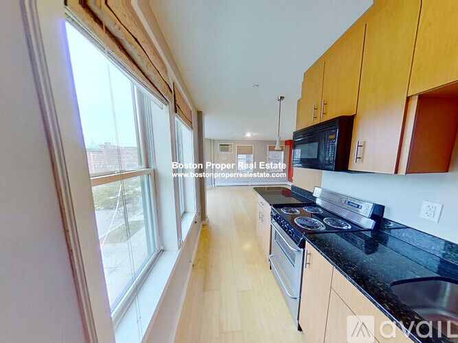 A kitchen with wooden cabinets and black countertops.