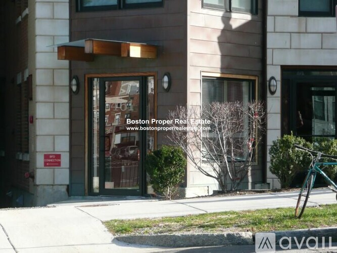 A building with a glass door and a sign that says Boston Proper Real Estate.