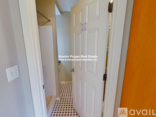 A hallway with a white door and a black and white checkered floor.