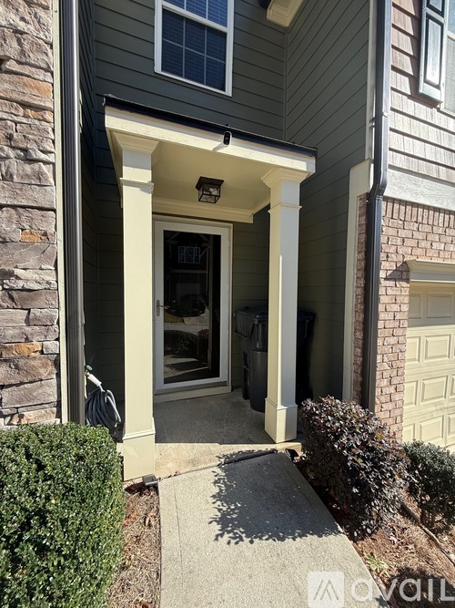 A house entrance with a glass door and a small window above it.
