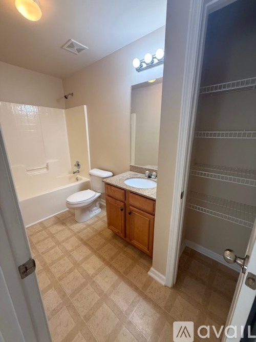 A bathroom with a toilet, sink, and mirror.