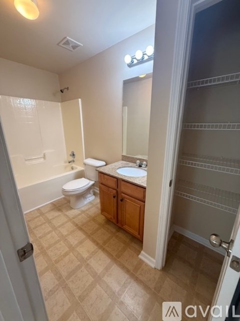 A bathroom with a toilet, sink, and mirror.