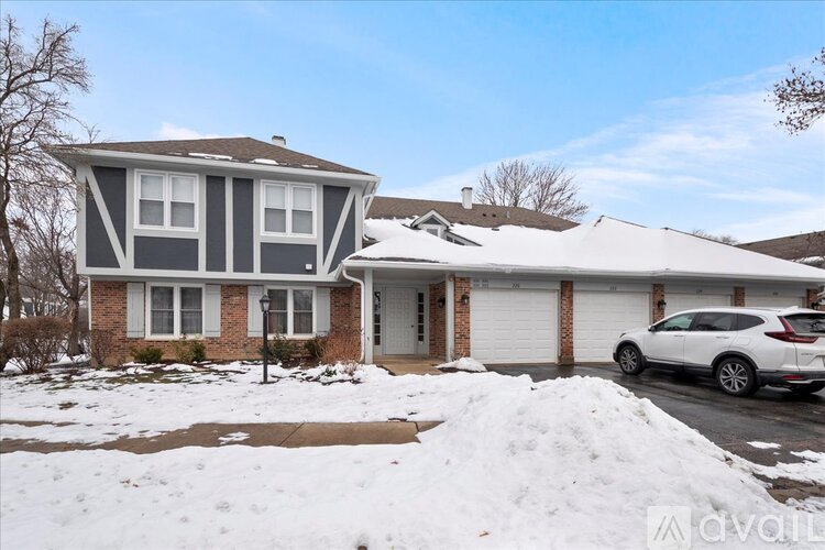 A house with a white car parked in front of it.