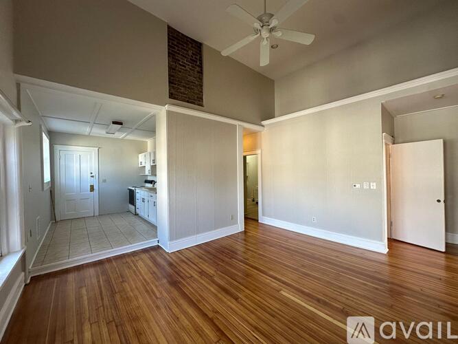 A room with wooden floors and a ceiling fan.