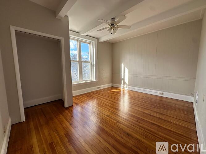 A room with wooden floors and a ceiling fan.
