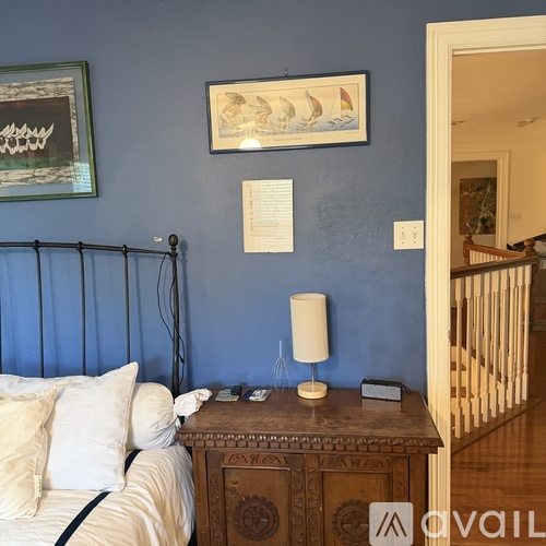 A bedroom with blue walls and a wooden dresser.