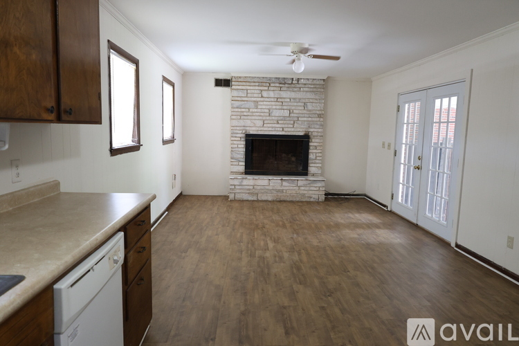 A living room with a fireplace and a ceiling fan.