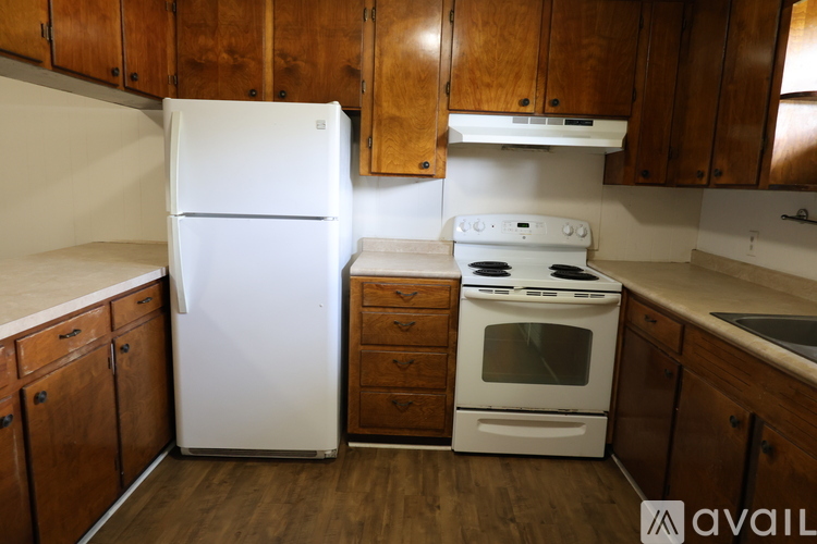 A kitchen with a white refrigerator and a white stove top oven.