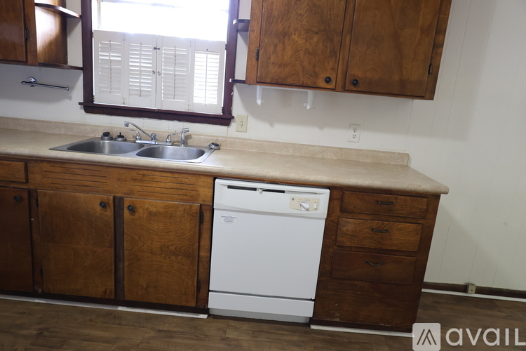 A kitchen with wooden cabinets and a white dishwasher.