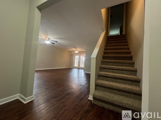 A staircase with a carpeted runner leads up to a doorway.