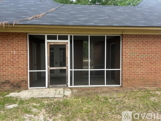 A brick building with a large glass door and window.