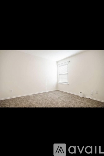 A room with a carpeted floor and a window.