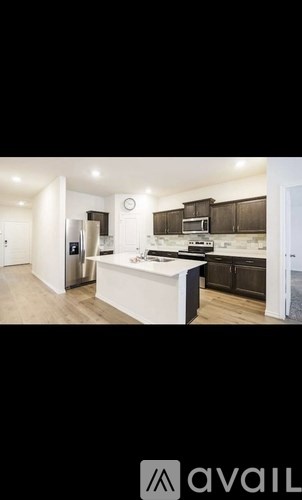 A modern kitchen with dark brown cabinets and a white island.