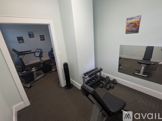 A gym room with a mirror, weights, and exercise equipment.