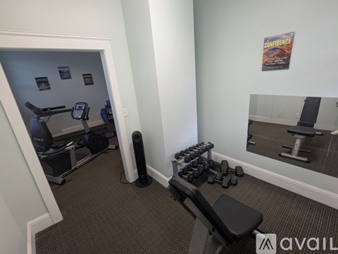 A gym room with a mirror, weights, and exercise equipment.