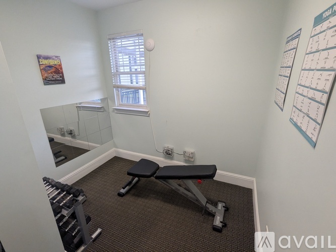 A room with a bench, weights, and a calendar on the wall.