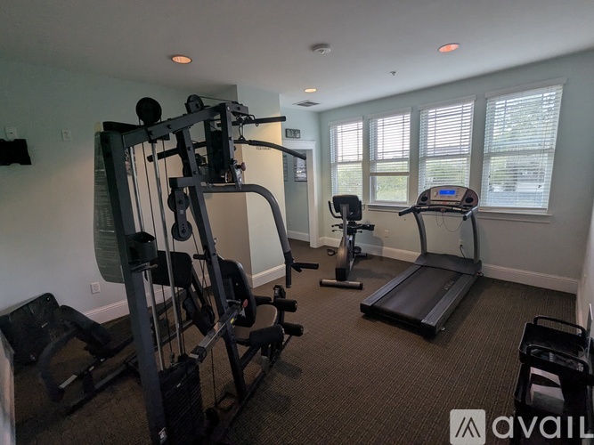 A well-equipped home gym with a treadmill, elliptical trainer, and weight machines.