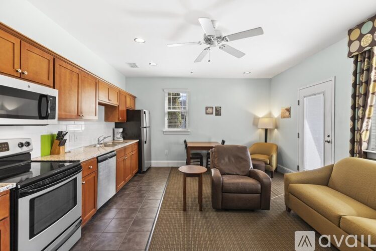 A kitchen with a refrigerator, microwave, and oven is available for rent.
