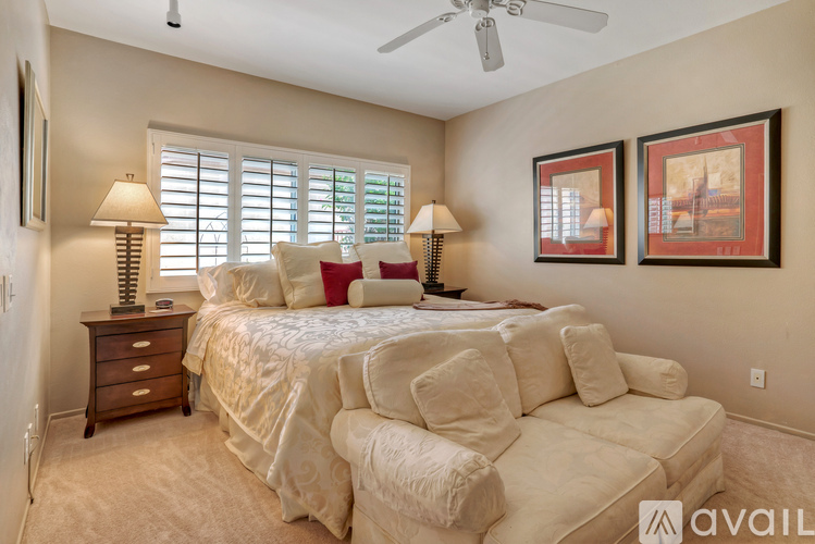 A bedroom with a large bed and two lamps.