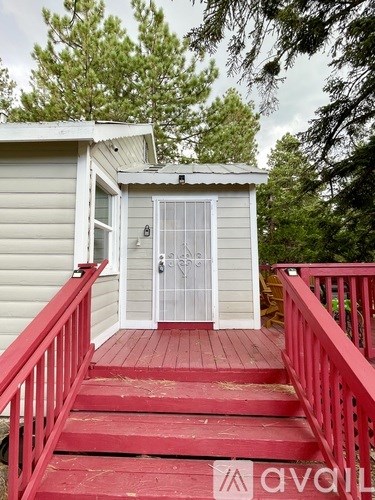 A small house with a red deck and a white door.