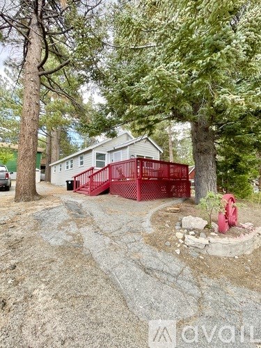 A red metal fence is in front of a house.