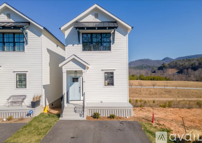 A white house with a blue door and windows is for sale.