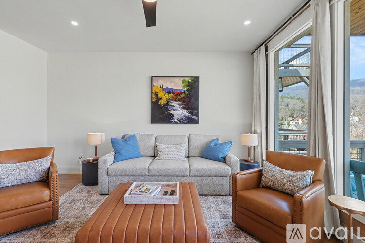 A bedroom with a large bed, a nightstand with a lamp, and a painting on the wall.