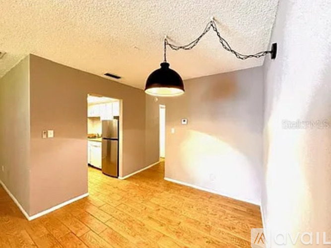 A room with wooden flooring and a hanging light fixture.