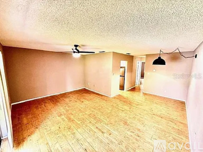A room with wooden flooring and a ceiling fan.