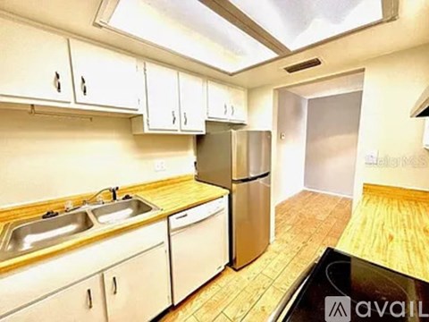 A kitchen with white cabinets and a wooden counter top.
