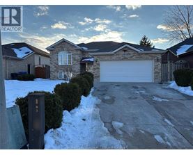 A house with a garage and a driveway in front of it.