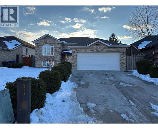 A house with a snow-covered driveway and a mailbox in front.