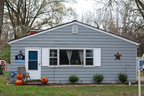A small house with a white door and a star on the window.
