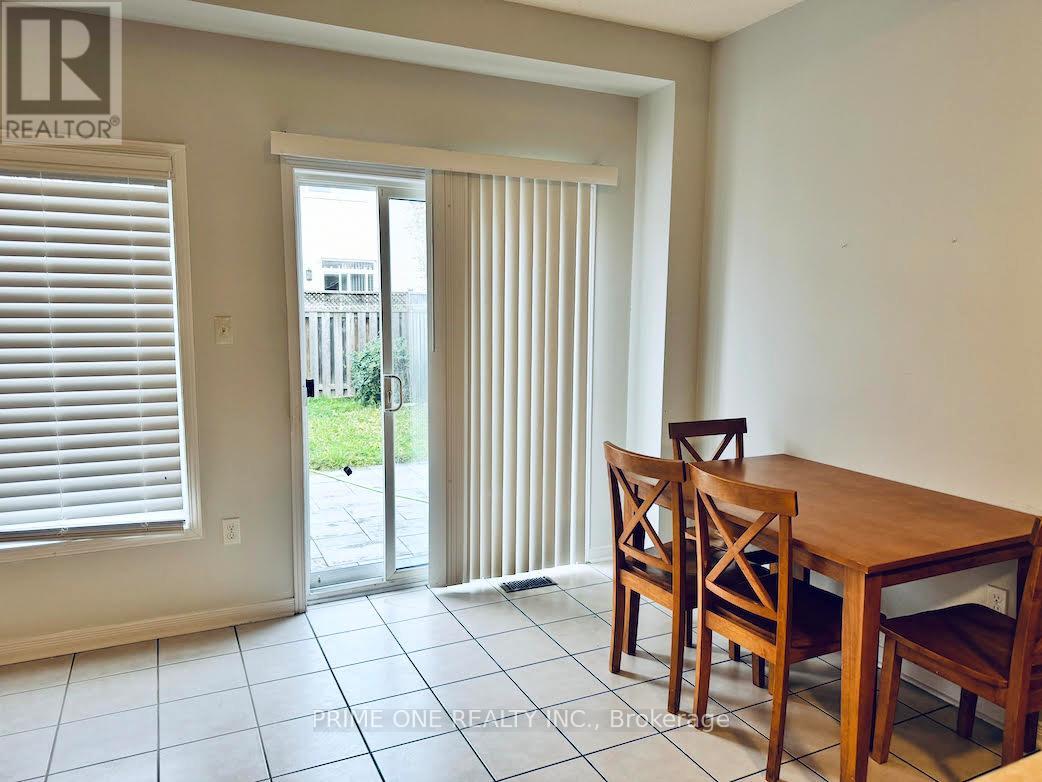 A room with a table and chairs and a sliding glass door.