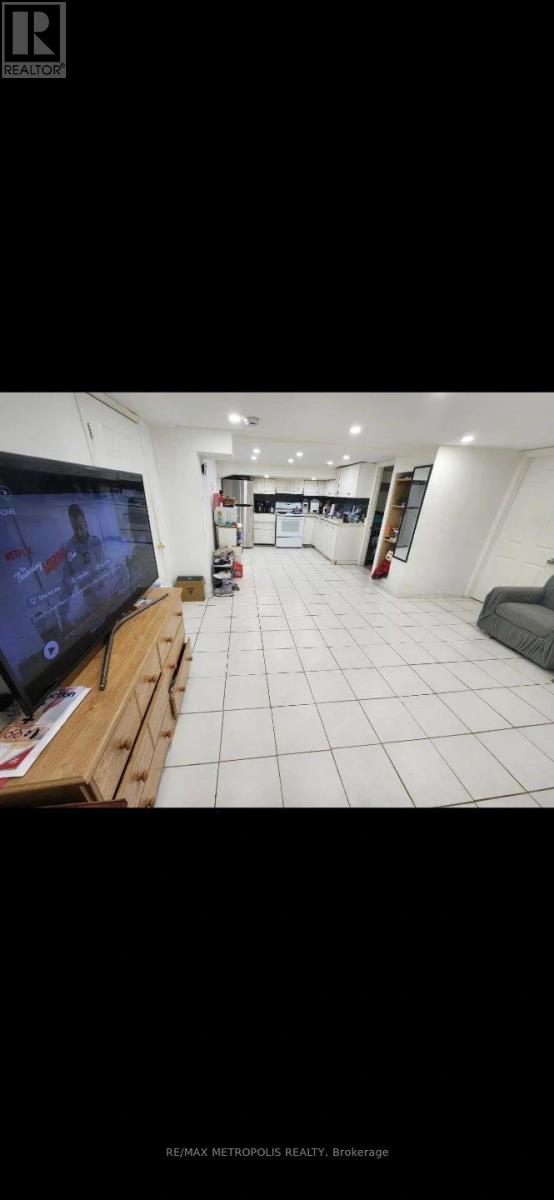 A room with a white tile floor and a television on a wooden stand.