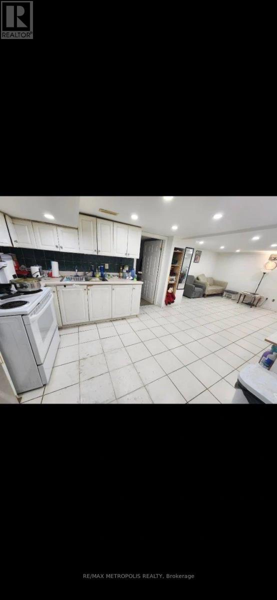 A kitchen with white cabinets and a white tiled floor.