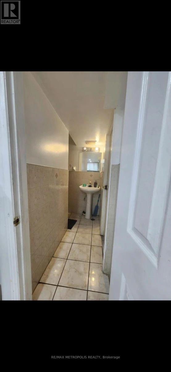 A bathroom with a toilet, sink, and mirror.