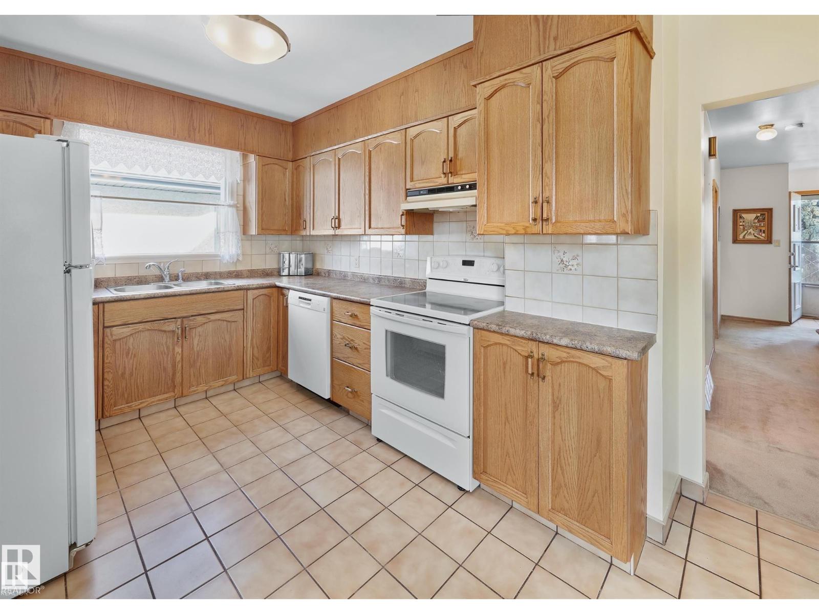 A kitchen with wooden cabinets and white appliances.