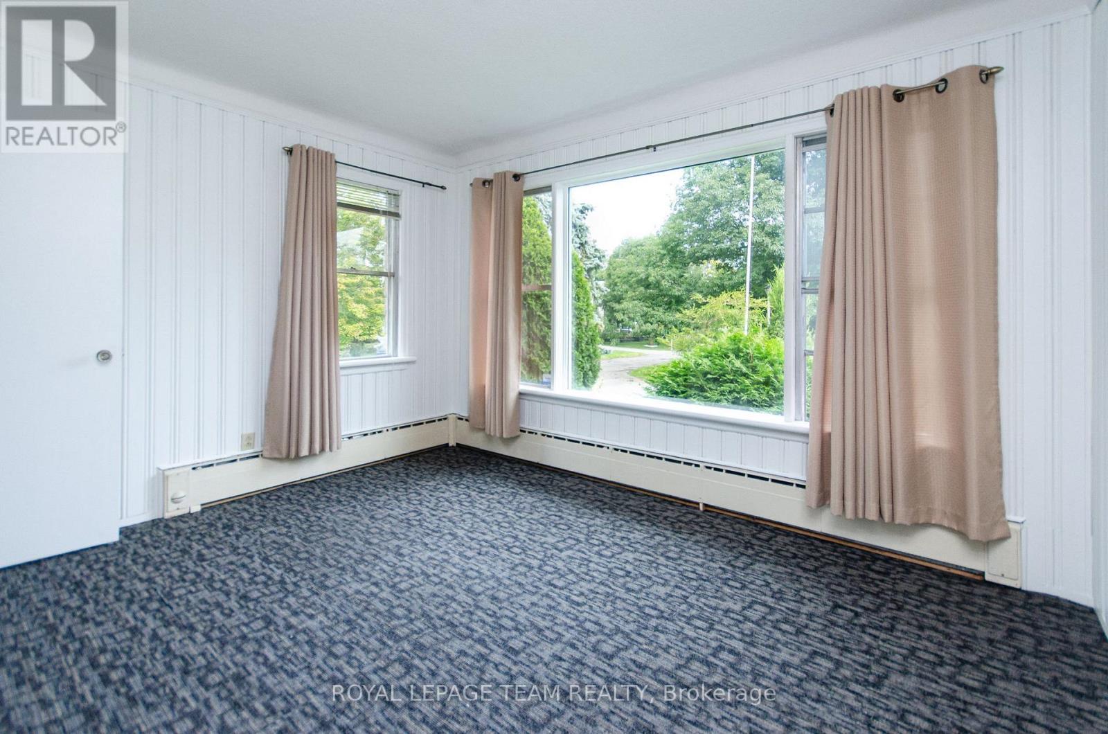 A bedroom with a large bed and a window with curtains.