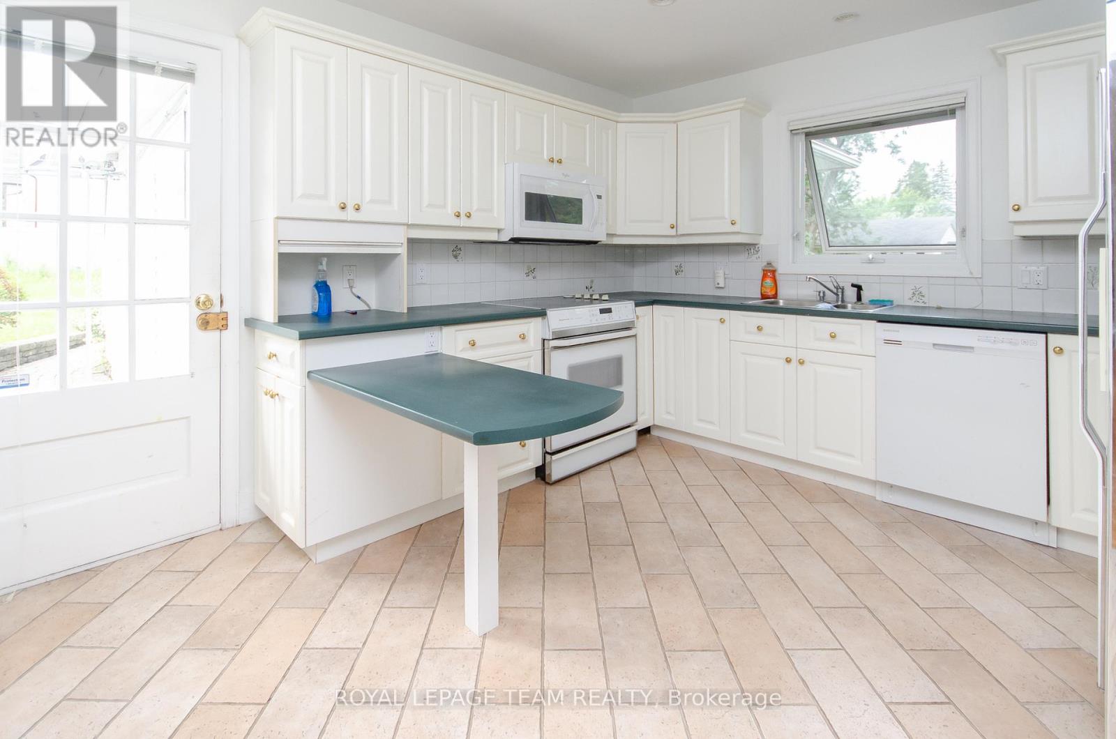 A kitchen with white cabinets and a green cutting board.