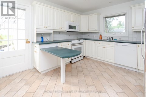 A kitchen with white cabinets and a green cutting board.