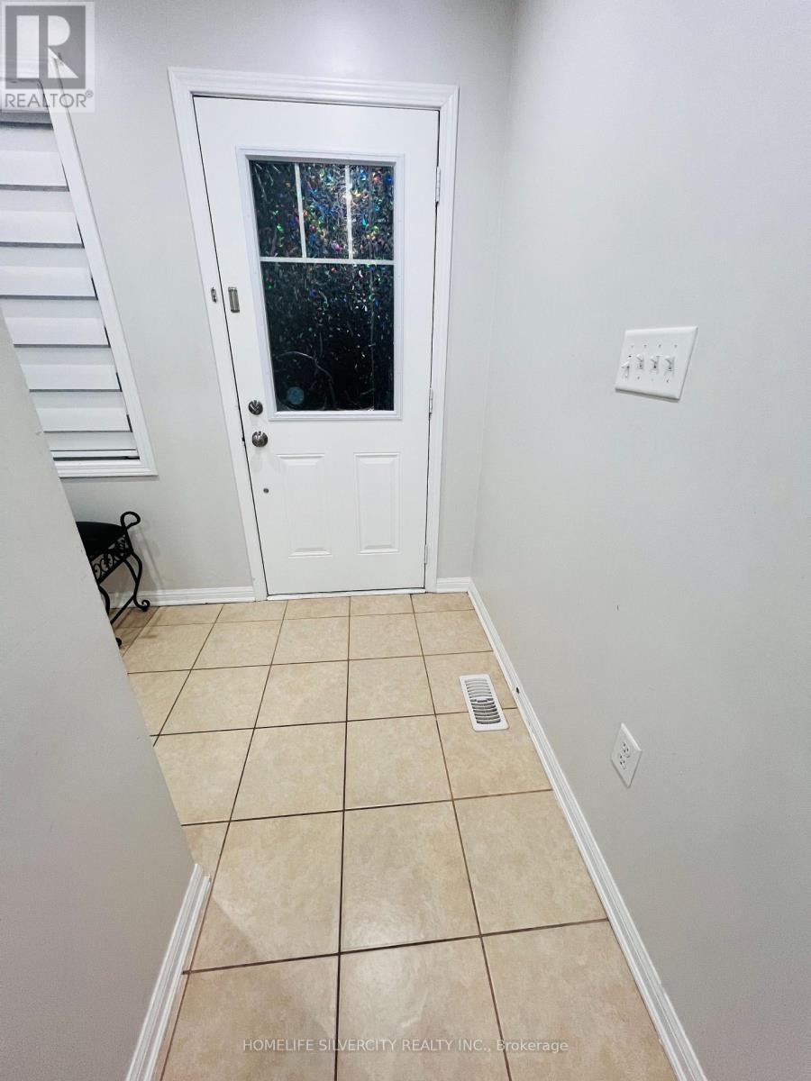 A white door with a glass window is in a room with a tiled floor.